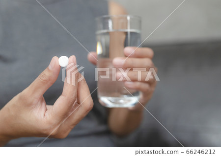 Close up of working woman taking in pill she is pours the pills out of the bottle,taking painkiller to reduce sharp ache concept,health care and medicine concept. Close up of working woman taking in pill she is pours the pills out of the bottle,taking painkiller to reduce sharp ache concept,health care and medicine concept. 66246212