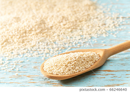 sesame seeds in a wooden spoon on a blue wooden 66246640