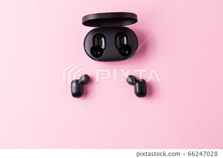 Close-up black wireless headphones on pink isolated background. Close-up black wireless headphones on pink isolated background. 66247028
