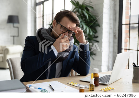 Sick male employee suffer from fever at workplace 66247090