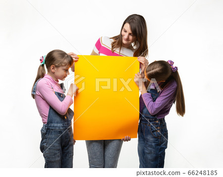 Mom and two daughters hold an orange sign in their Mom and two daughters hold an orange sign in their 66248185