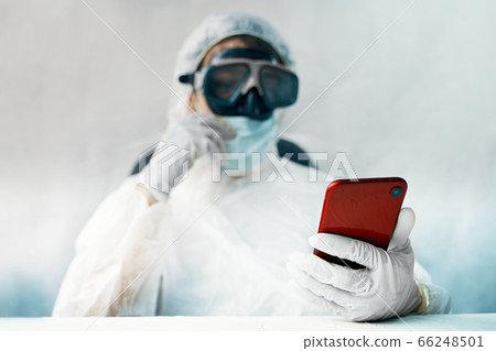Doctor in the protective suit with smartphone Doctor in the protective suit with smartphone 66248501