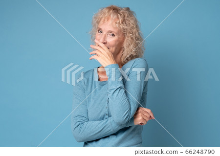 shy caucasian mature woman smiling with hand on her mouth shy caucasian mature woman smiling with hand on her mouth 66248790