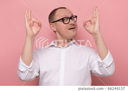 Portrait of a happy mature man showing ok gesture and looking at camera Portrait of a happy mature man showing ok gesture and looking at camera 66249137