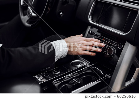 Young man using automobile audio stereo system Young man using automobile audio stereo system 66250616