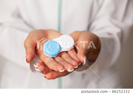 Doctor holding a container with contact lenses Doctor holding a container with contact lenses 66252152