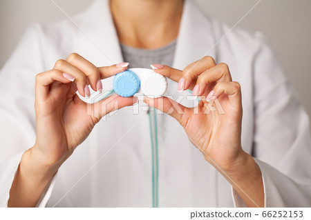 Doctor holding a container with contact lenses Doctor holding a container with contact lenses 66252153