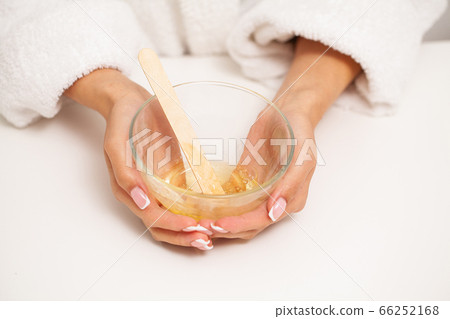 Skin care, woman holding a plate of wax for depilation 66252168