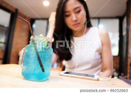 Young woman listening to music in coffee shop Young woman listening to music in coffee shop 66252663