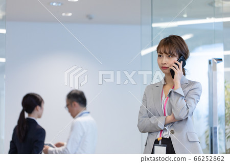 A female employee who contacts with a smartphone during a meeting A female employee who contacts with a smartphone during a meeting 66252862