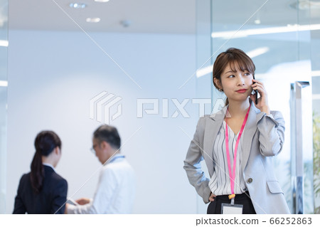 A female employee who contacts with a smartphone during a meeting A female employee who contacts with a smartphone during a meeting 66252863