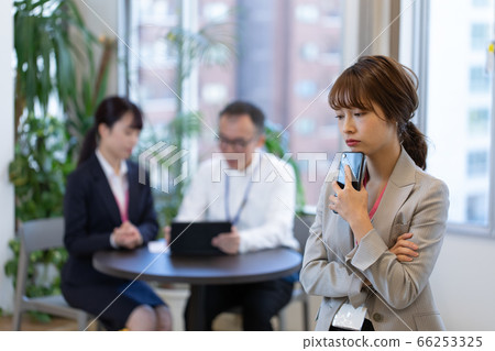 A female employee who contacts with a smartphone during a meeting 66253325
