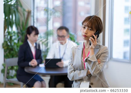 A female employee who contacts with a smartphone during a meeting A female employee who contacts with a smartphone during a meeting 66253330
