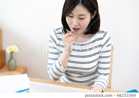 A middle-aged woman making a videophone toward a personal computer A middle-aged woman making a videophone toward a personal computer 66253369