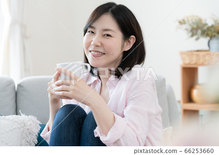 Woman relaxing in the living room with coffee 66253660