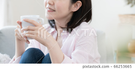 Woman relaxing in the living room with coffee Woman relaxing in the living room with coffee 66253665