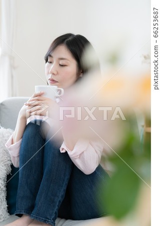Woman relaxing in the living room with coffee Woman relaxing in the living room with coffee 66253687