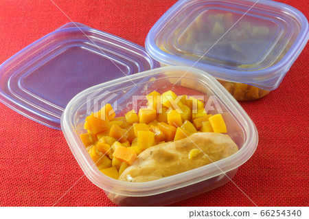 Packing Chicken breast with gravy and butternut squash leftovers in single serving meal plastic containers for freezing 66254340