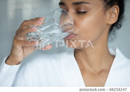 Close up beautiful African American woman drinking pure water 66258247