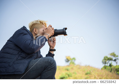 Young photographer sitting on his pickup truck Young photographer sitting on his pickup truck 66258842