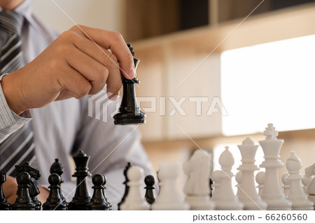 hand of businessman moving chess in competition, shows leadership, followers and business success strategies hand of businessman moving chess in competition, shows leadership, followers and business success strategies 66260560
