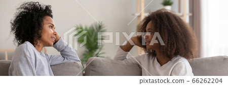 African mother chatting with daughter seated on couch at home African mother chatting with daughter seated on couch at home 66262204
