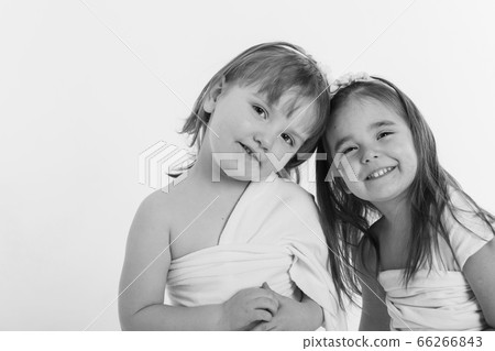 two little happy girls smiling on white background. Portrait of children hugging. The concept of relationships in the family, friends, sisters, couple in love. Copy space 66266843