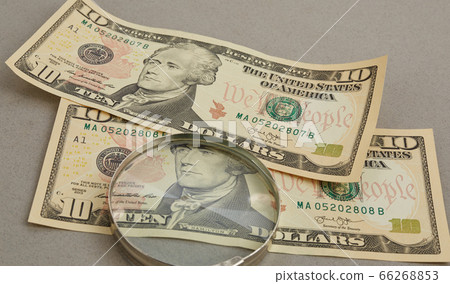 finance. magnifying glass over paper banknotes on 66268853