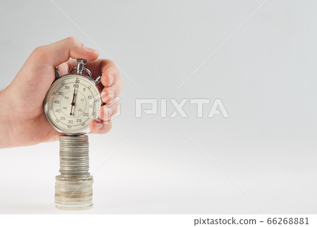 time is money. hand holding a stopwatch on a stack time is money. hand holding a stopwatch on a stack 66268881