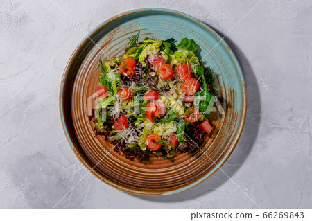 Salmon Salad. Salted salmon, mixed salad, grapefruit, Parmesan cheese, pine nuts in the dark plate 66269843
