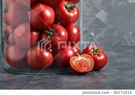 Red tomatoes in a glass vase on a gray background Close-up, tomato concept, copy space. Photos for grocery stores Red tomatoes in a glass vase on a gray background Close-up, tomato concept, copy space. Photos for grocery stores 66272018