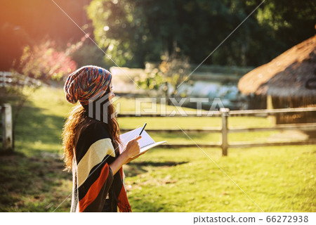 Asian woman relax in the holiday. Travel nature and  write a note in the notebook at the park 66272938