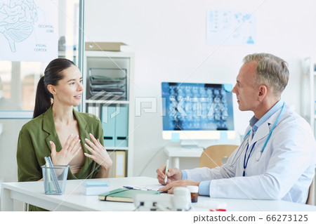 Young Woman Talking to Doctor in Clinic Young Woman Talking to Doctor in Clinic 66273125