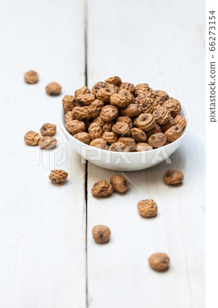 Tigernuts in a bowl on a wooden surface Tigernuts in a bowl on a wooden surface 66273154
