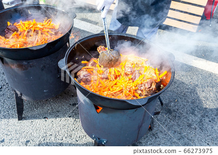 Cooking appetizing traditional food in a large 66273975