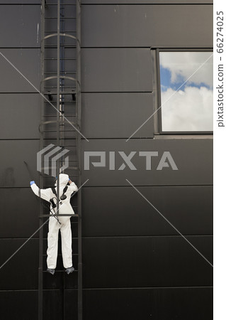 Abstract Background of Worker Disinfecting Black Facade 66274025
