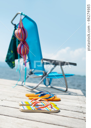 flip-flops, bikini and swimming trunks on a pier flip-flops, bikini and swimming trunks on a pier 66274985