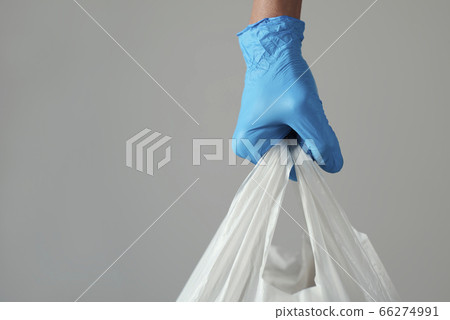 man wearing latex gloves carrying a shopping bag man wearing latex gloves carrying a shopping bag 66274991