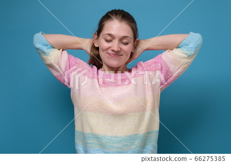 Young caucasian woman with closed eyes relaxing with hands behind head, Young caucasian woman with closed eyes relaxing with hands behind head, 66275385