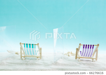 COVID 19 protection on beach vacation. Separation, social distancing at summer holidays. Deckchairs separated by glass partitions on sand background. COVID 19 protection on beach vacation. Separation, social distancing at summer holidays. Deckchairs separated by glass partitions on sand background. 66276616