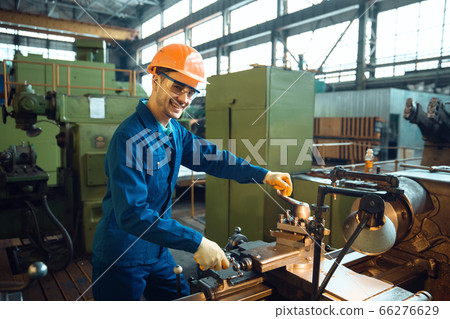 Male worker checks turning lathe on plant Male worker checks turning lathe on plant 66276629