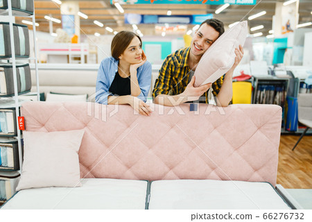 Couple poses at the pink couch in furniture store 66276732