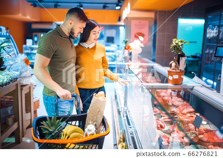 Couple choosing fresh chilled meat, grocery store 66276821