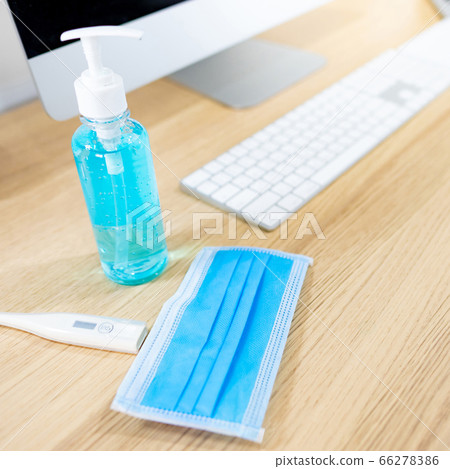 Hand sanitizer, mask and thermometer on desk Hand sanitizer, mask and thermometer on desk 66278386