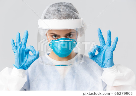 Covid-19, preventing virus, health, healthcare workers and quarantine concept. Close-up serious, determined female doctor or nurse in personal protective equipment, face mask and gloves, show okay Covid-19, preventing virus, health, healthcare workers and quarantine concept. Close-up serious, determined female doctor or nurse in personal protective equipment, face mask and gloves, show okay 66279905