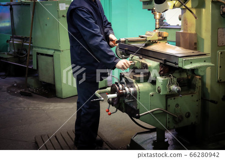 A male worker works on a larger metal iron 66280942