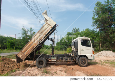 Dump truck unloading soil at construction site. Dump truck unloading soil at construction site. 66282099
