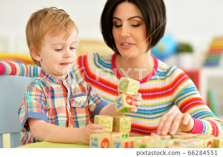 Woman and little boy playing with cubes 66284551