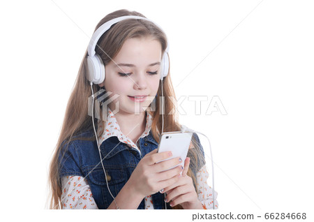 Happy little girl in jeans jacket listening music with smartphone 66284668