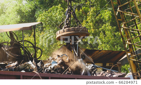 Image of industrial electric magnet lifting metal details and part on the junkyard 66284971